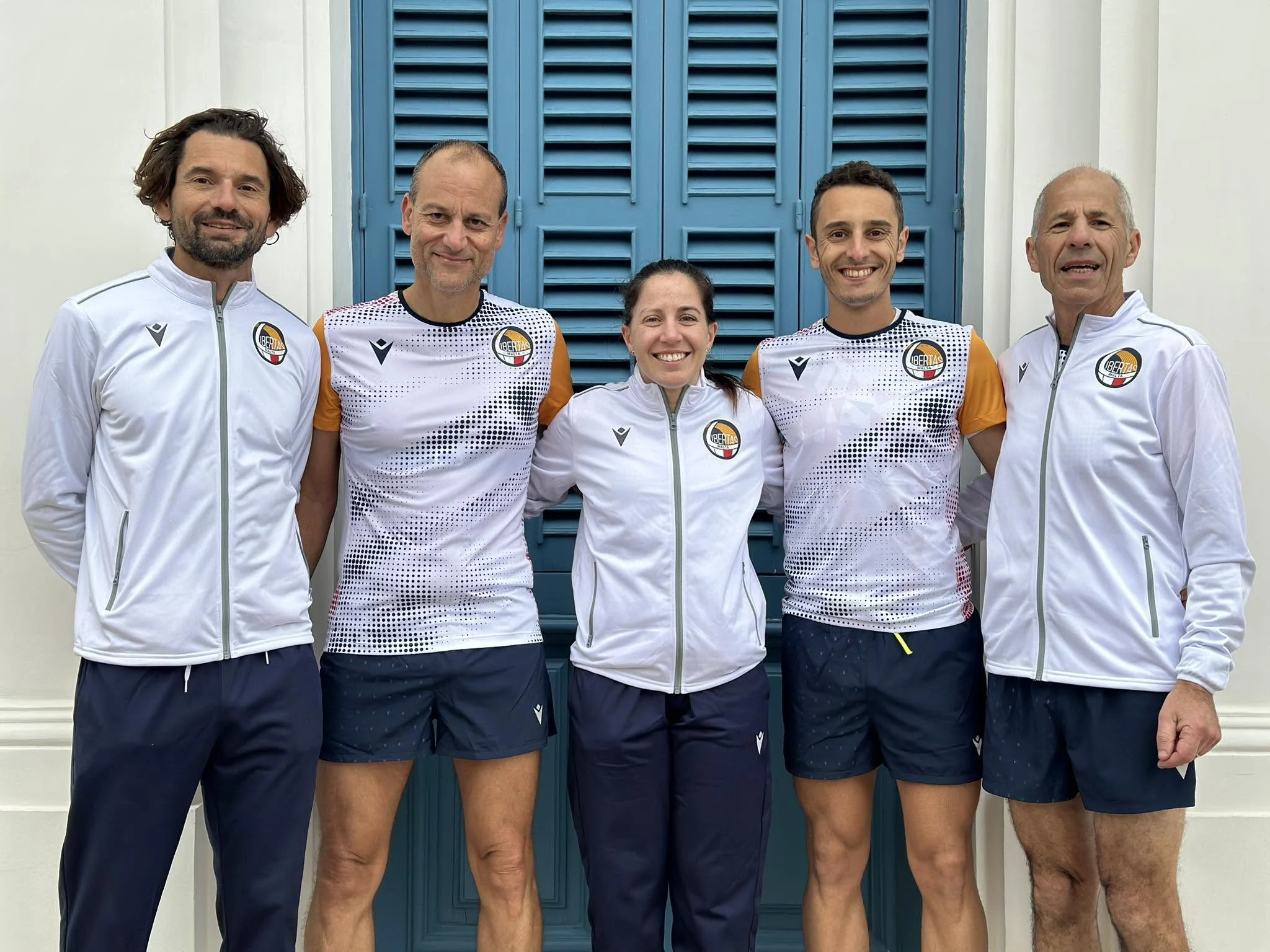 Five Libertas Malta athletes and coaches standing together in club kit